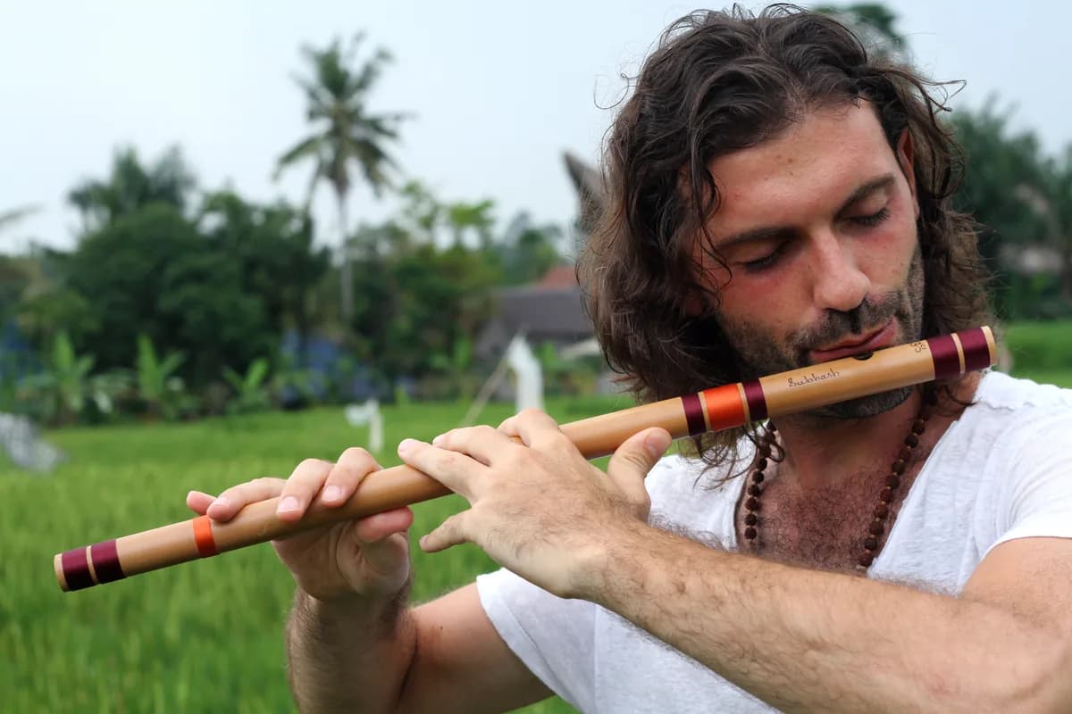 Playing bamboo flute in tropical rice fields