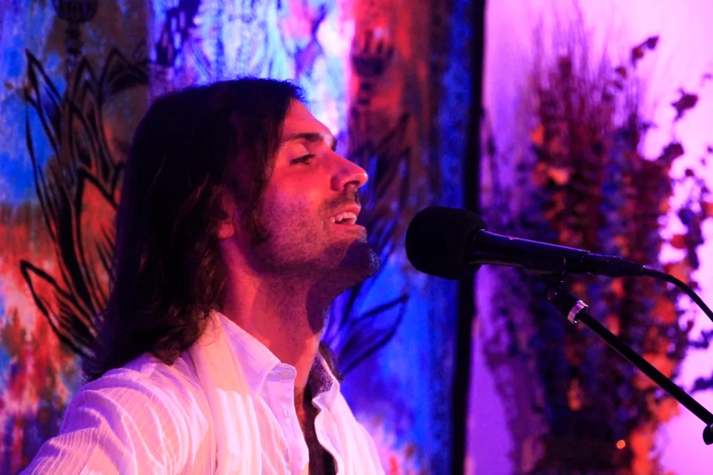 Performing with guitar on colorful stage